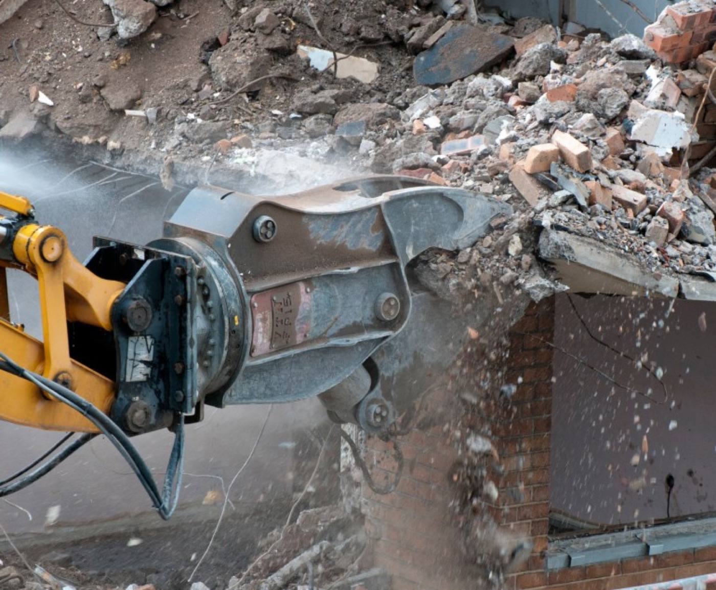 A pulveriser working masonry under dust suppression